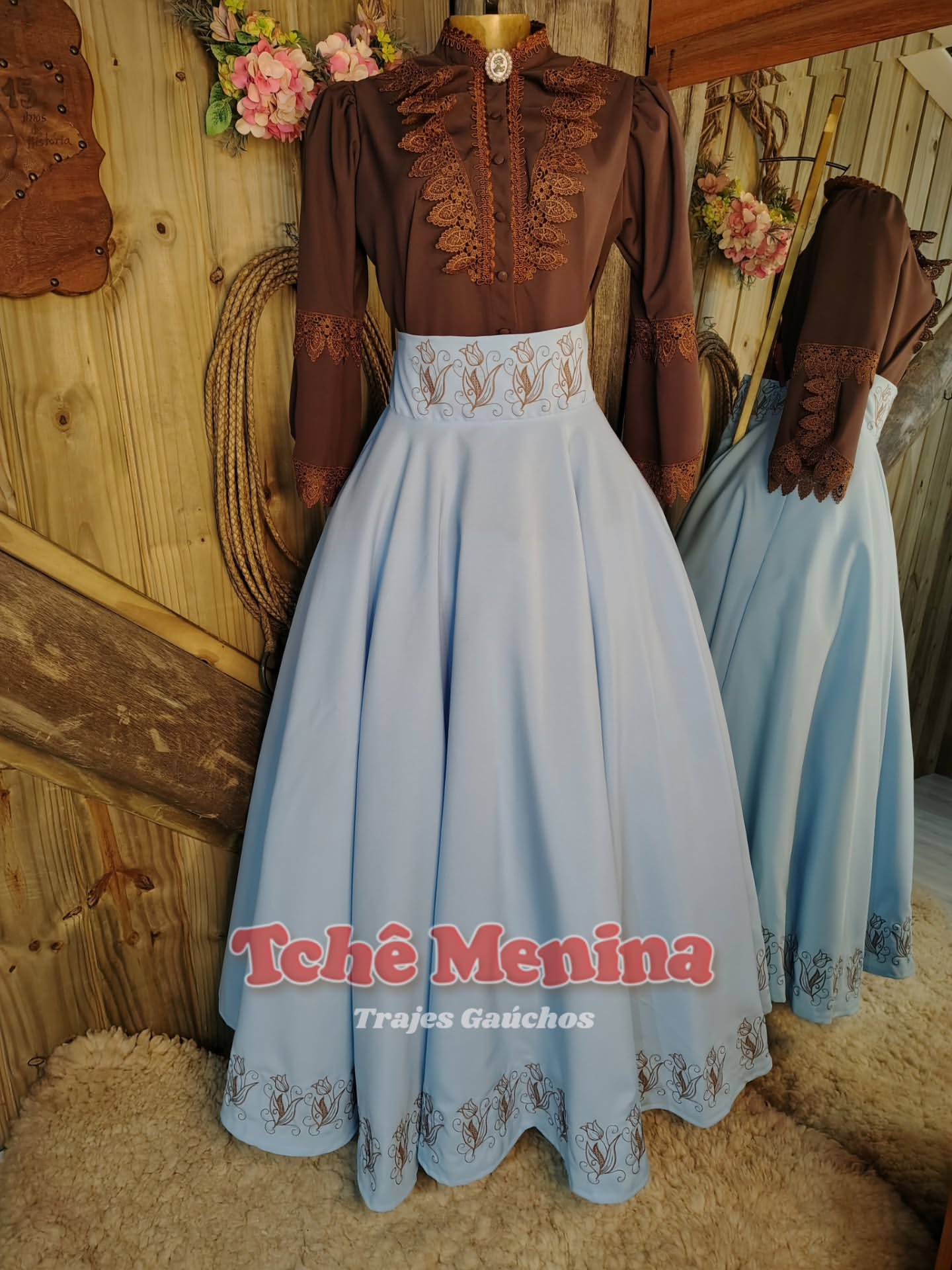 Conjunto exclusivo de prenda: blusa marrom bordada e saia azul bebê