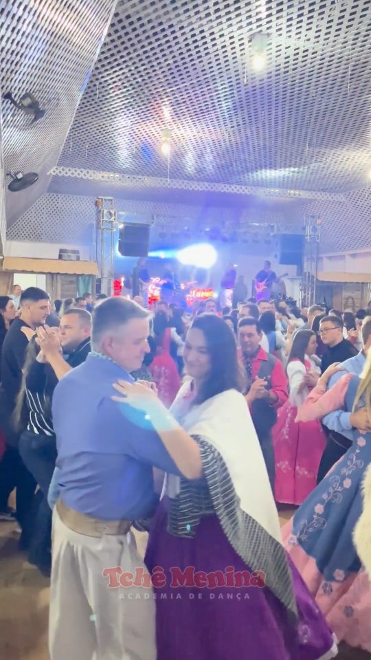 Prendas e peões dançando no baile gaúcho